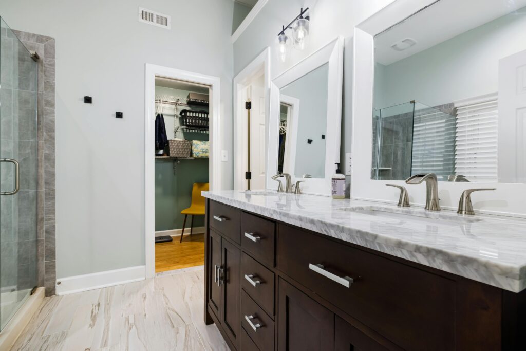 Contemporary bathroom featuring marble countertop, sleek design, and ample lighting.
