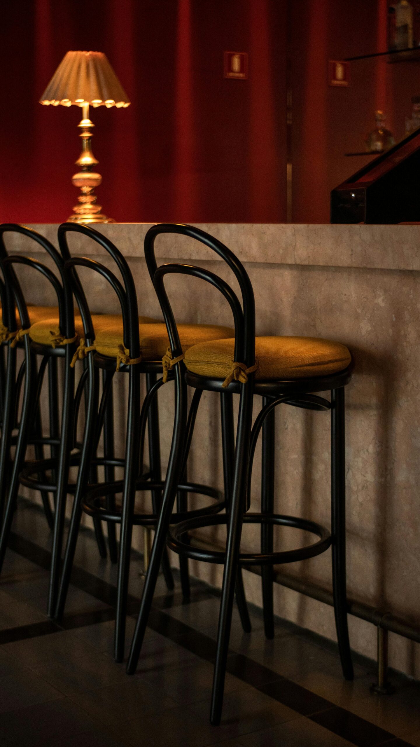 Luxurious bar interior featuring stylish stools and warm lighting.